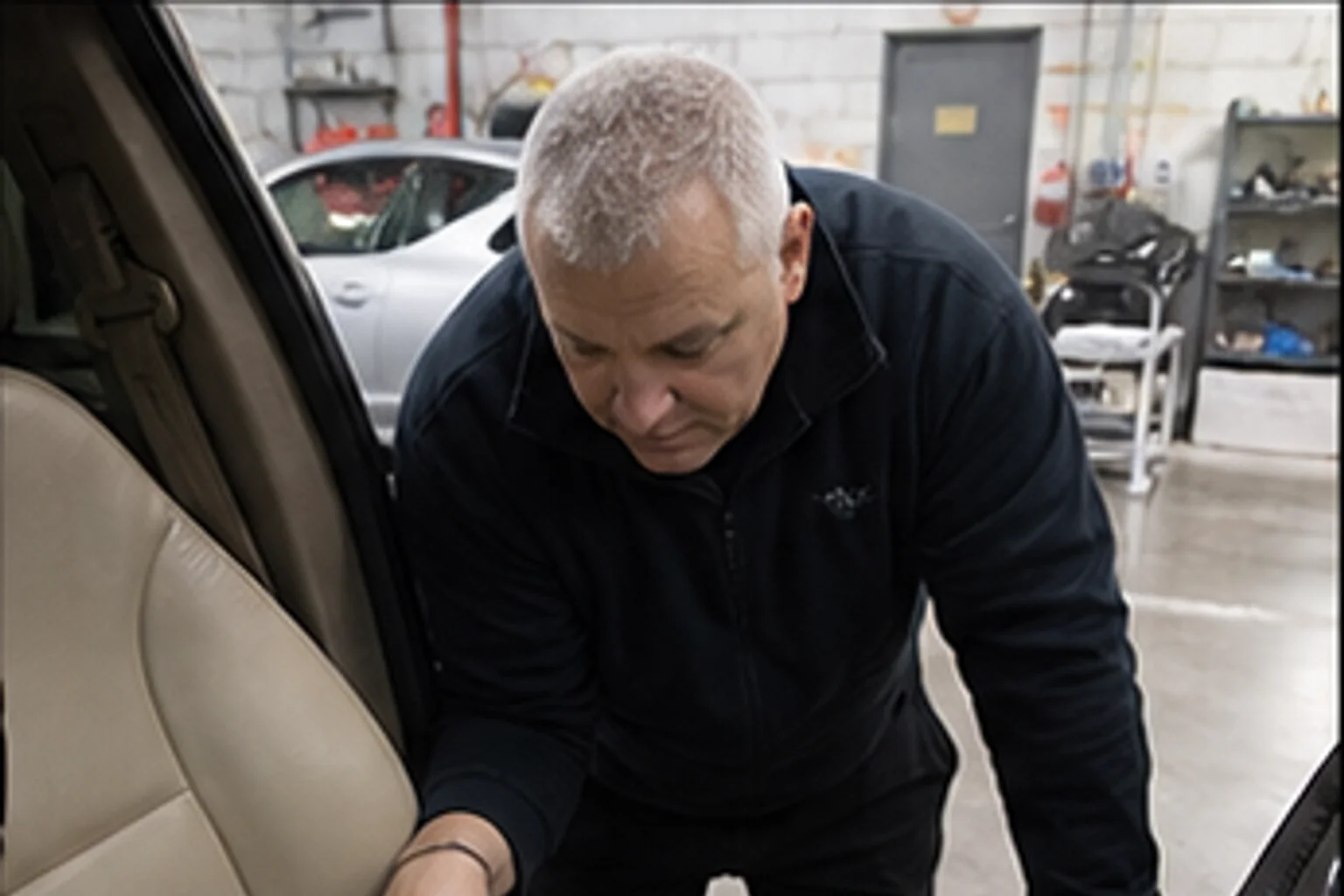 Technician inspecting repair work inside the Invisible Touch collision bay
